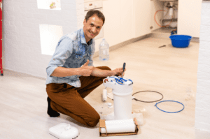A man installs a water filtration system